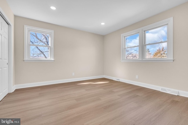 unfurnished bedroom featuring a closet, light wood-type flooring, visible vents, and baseboards