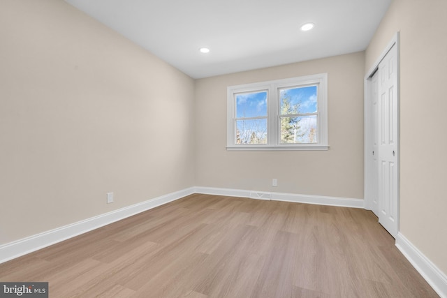 unfurnished bedroom featuring light wood-type flooring, baseboards, and recessed lighting