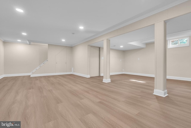 finished basement featuring light wood-type flooring, crown molding, baseboards, and recessed lighting