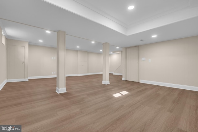 finished basement with light wood-style floors, baseboards, crown molding, and recessed lighting