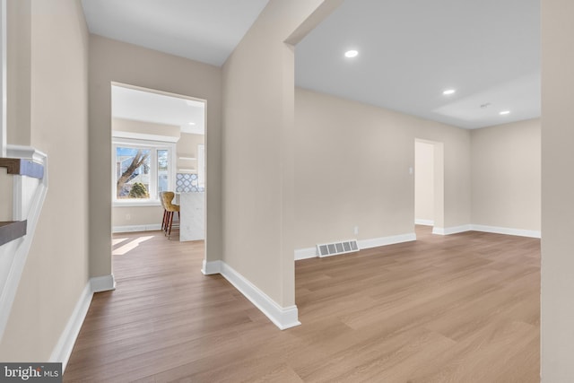 corridor with recessed lighting, visible vents, baseboards, and wood finished floors