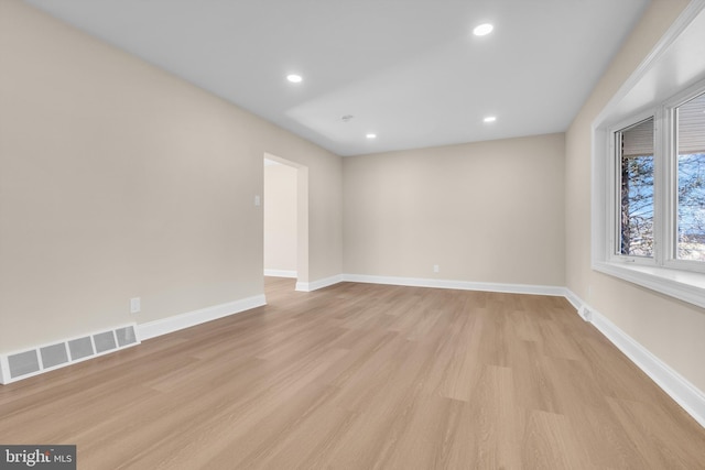 unfurnished room with light wood-style floors, baseboards, visible vents, and recessed lighting