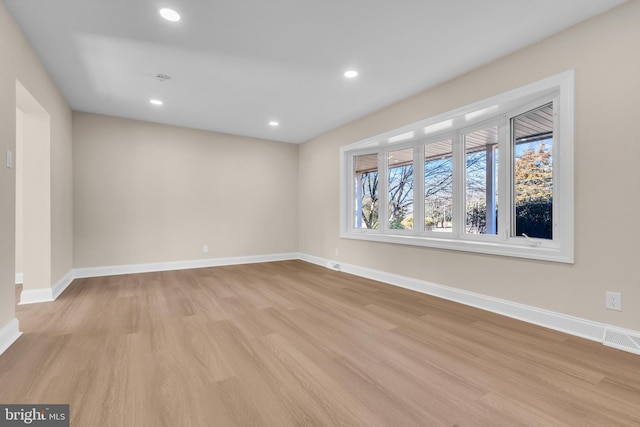 empty room with recessed lighting, light wood-type flooring, visible vents, and baseboards