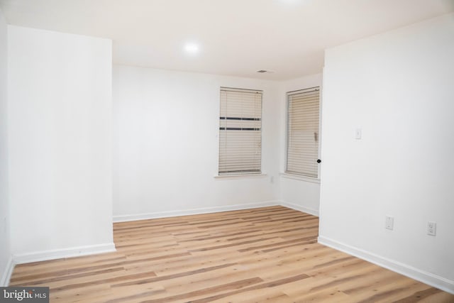 empty room with baseboards and light wood finished floors