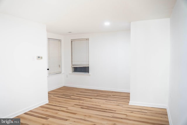 empty room with light wood-style flooring, baseboards, and recessed lighting