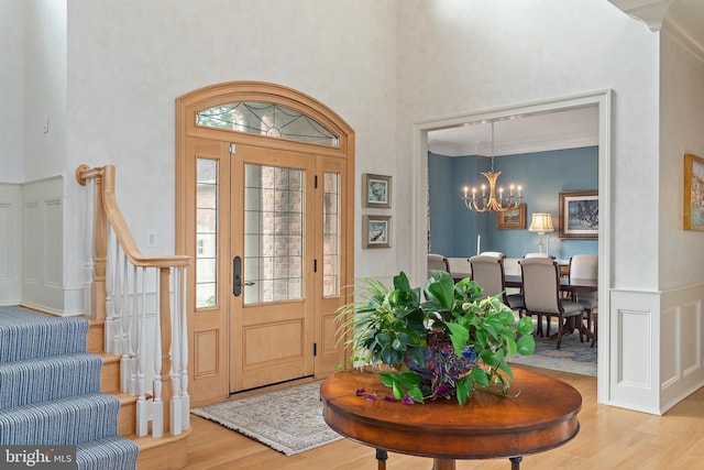 1556 Widows Mite Rd, Edgewater, MD 21037 - foyer with wood finished floors, a towering ceiling, a chandelier, stairs, and wainscoting