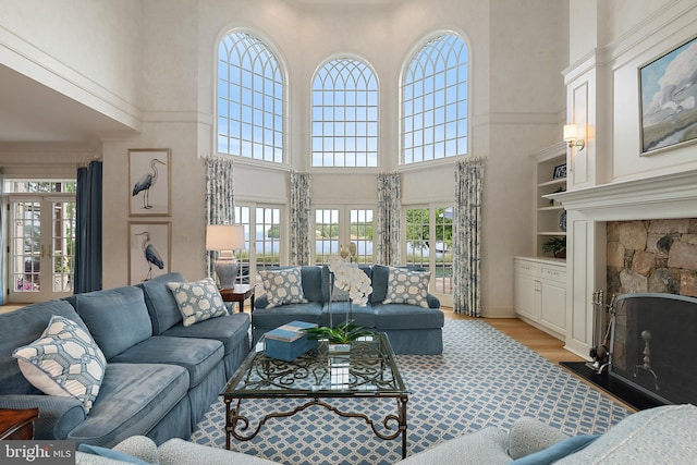 1556 Widows Mite Rd, Edgewater, MD 21037 - living room featuring french doors, a towering ceiling, wood finished floors, and a fireplace