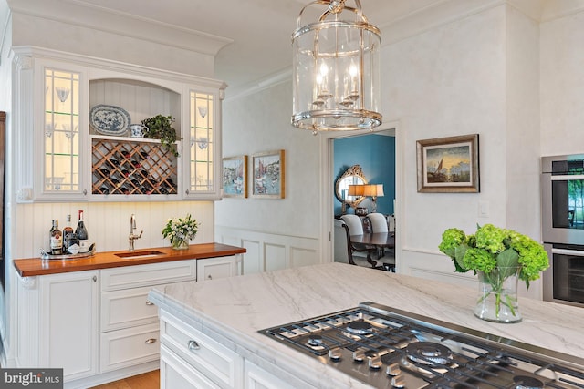 1556 Widows Mite Rd, Edgewater, MD 21037 - kitchen featuring stainless steel appliances, butcher block counters, a chandelier, glass insert cabinets, and a decorative wall