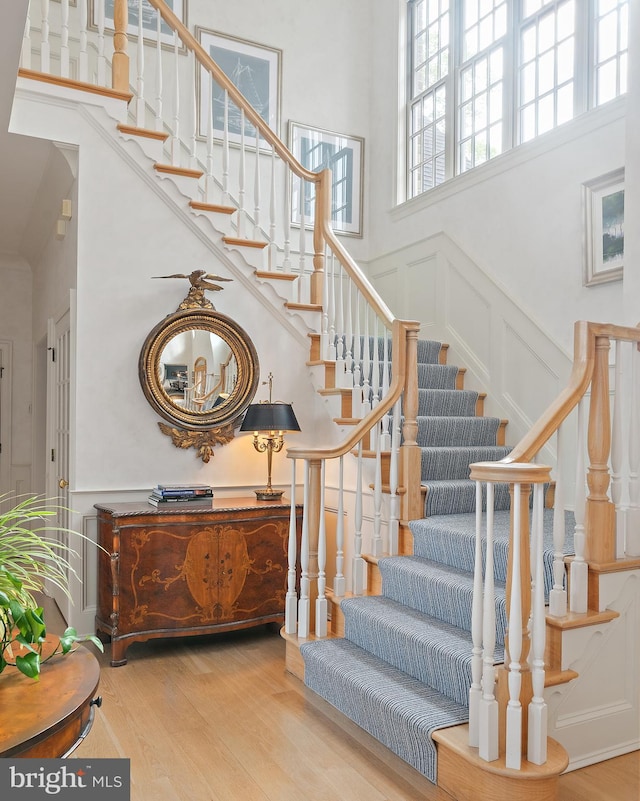 1556 Widows Mite Rd, Edgewater, MD 21037 - stairway featuring a towering ceiling, wood finished floors, and a decorative wall