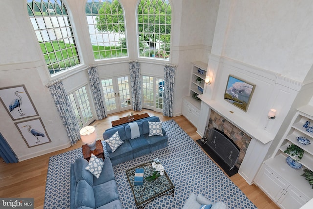 1556 Widows Mite Rd, Edgewater, MD 21037 - living room featuring a towering ceiling, light wood-style floors, french doors, built in features, and a water view