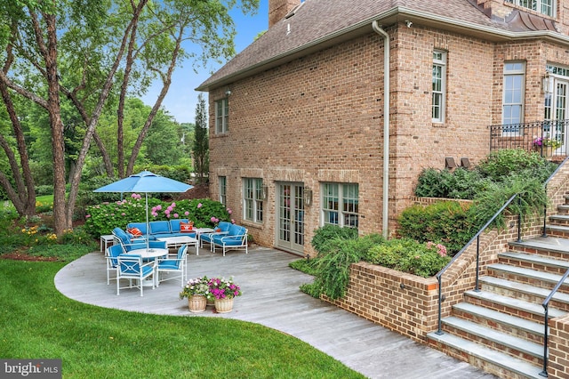 1556 Widows Mite Rd, Edgewater, MD 21037 - rear view of house featuring a shingled roof, an outdoor hangout area, stairs, brick siding, and a patio