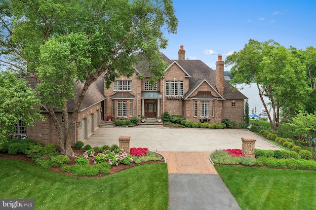 1556 Widows Mite Rd, Edgewater, MD 21037 - view of front facade with driveway, an attached garage, brick siding, and a front lawn