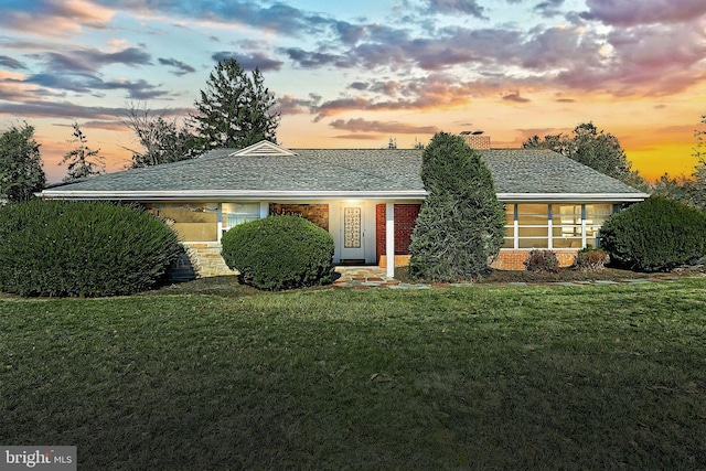 ranch-style home with a lawn