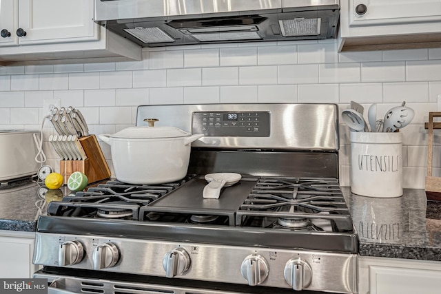 interior details featuring white cabinetry, dark countertops, stainless steel range with gas stovetop, and decorative backsplash