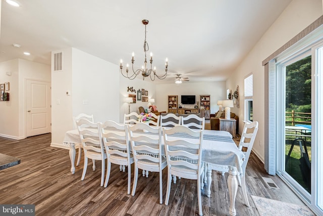 dining area featuring baseboards, visible vents, wood finished floors, and ceiling fan with notable chandelier