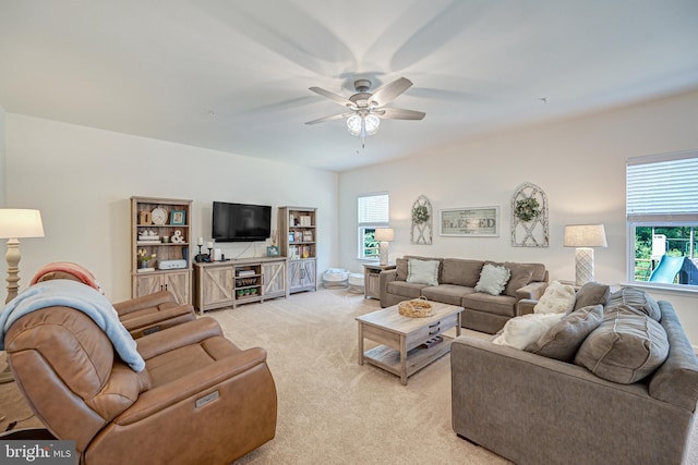 living room featuring a ceiling fan, a healthy amount of sunlight, and light colored carpet