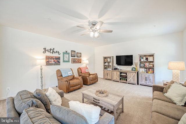 living area featuring light carpet, a ceiling fan, and baseboards