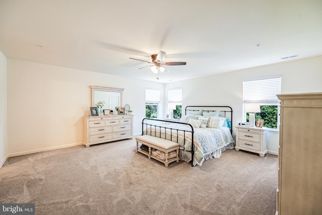 bedroom with visible vents, multiple windows, light carpet, and baseboards