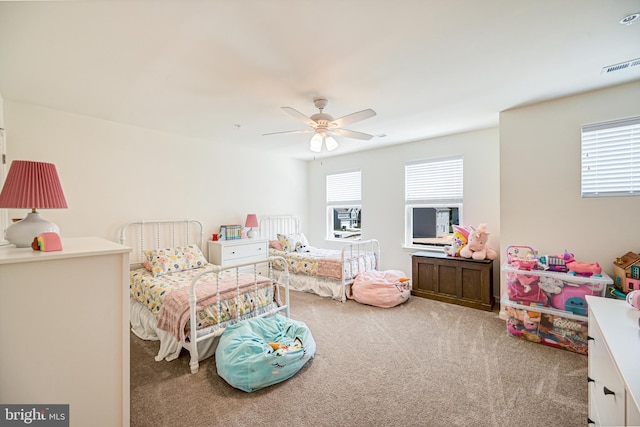 bedroom with multiple windows, carpet flooring, visible vents, and a ceiling fan