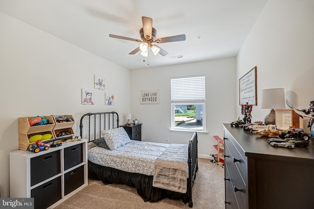 bedroom with light carpet, ceiling fan, visible vents, and baseboards