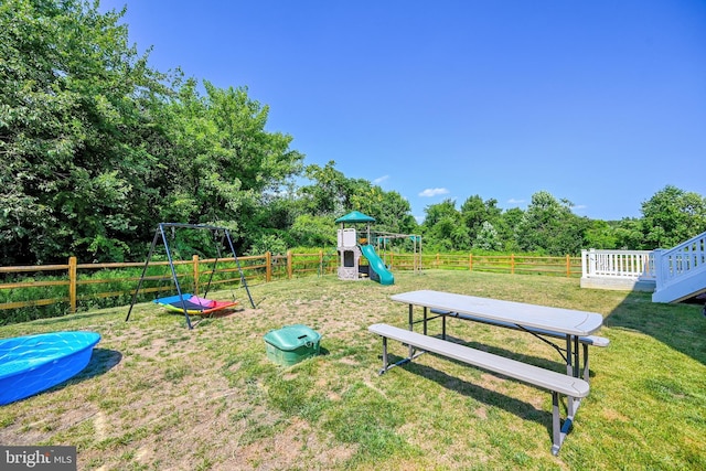 view of jungle gym featuring fence and a yard