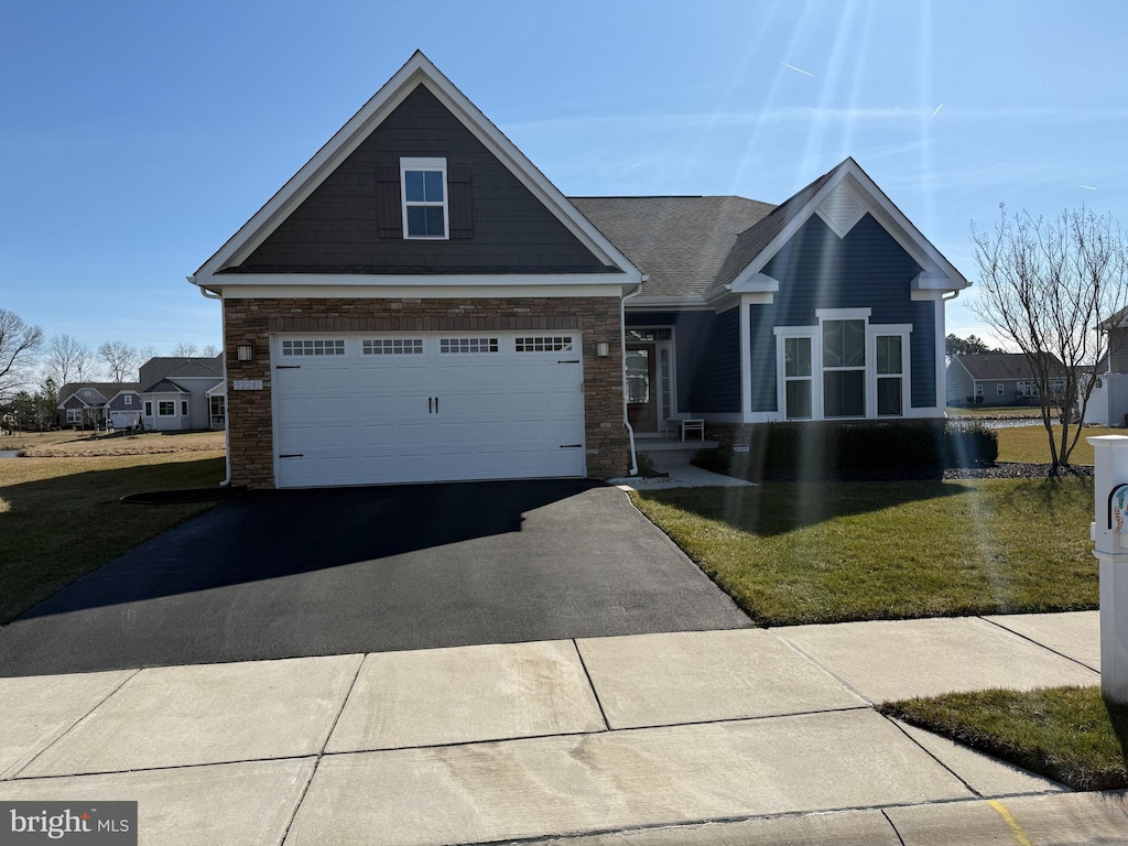 craftsman inspired home with a front lawn and aphalt driveway