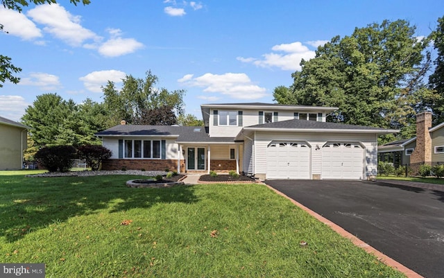 view of front of property with driveway, brick siding, an attached garage, and a front yard