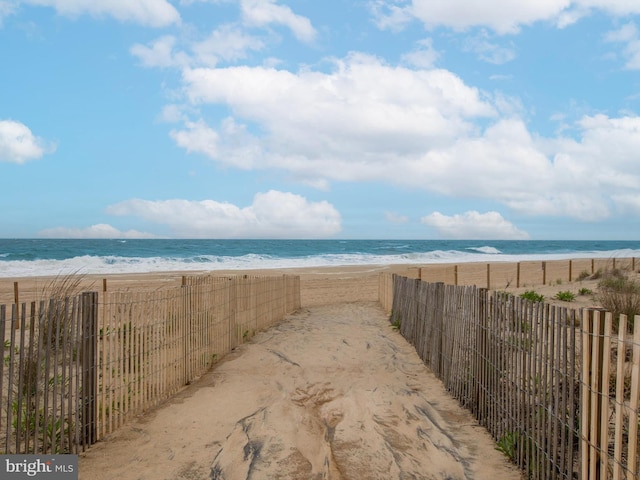 water view with a beach view and fence