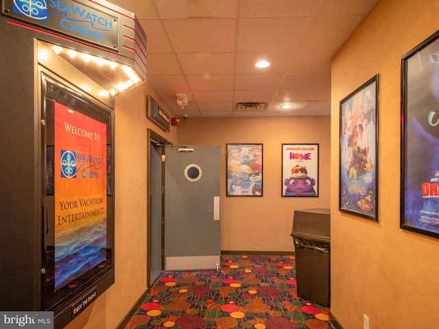 corridor featuring a paneled ceiling, recessed lighting, visible vents, and baseboards