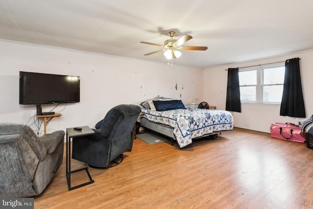 bedroom with ceiling fan, light wood finished floors, and crown molding