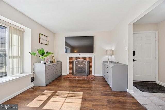 living room with dark wood-style floors, a fireplace, and baseboards