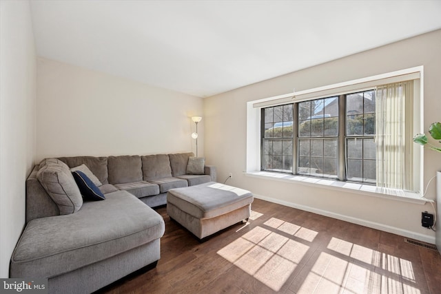 living area featuring dark wood-style flooring and baseboards