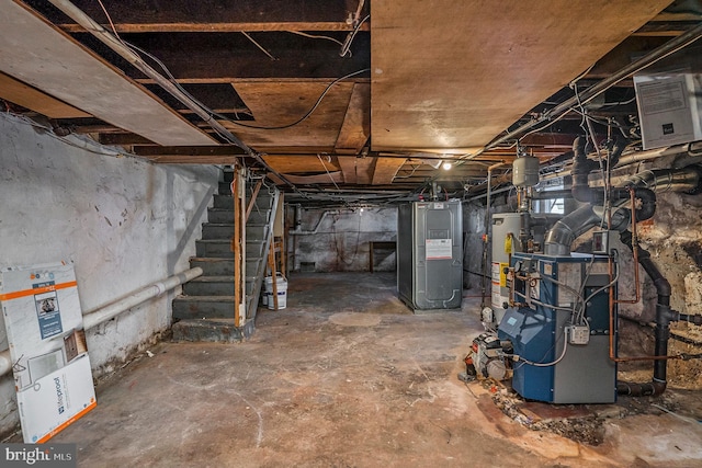 basement featuring stairway, hybrid water heater, and water heater