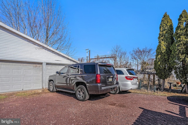 exterior space featuring a garage and dirt driveway