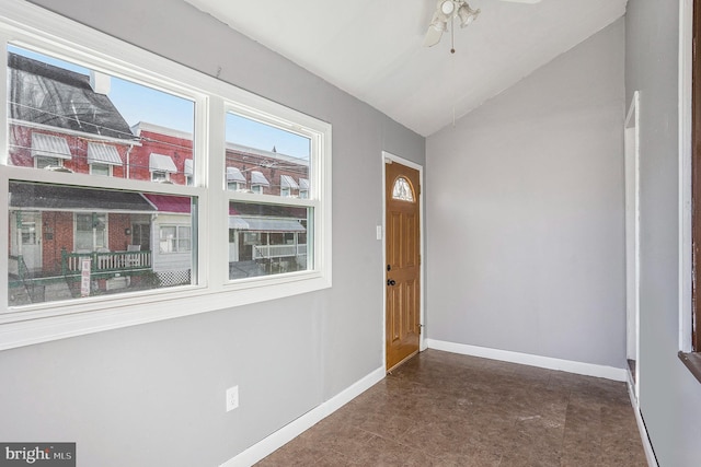 foyer entrance with vaulted ceiling, baseboards, and ceiling fan