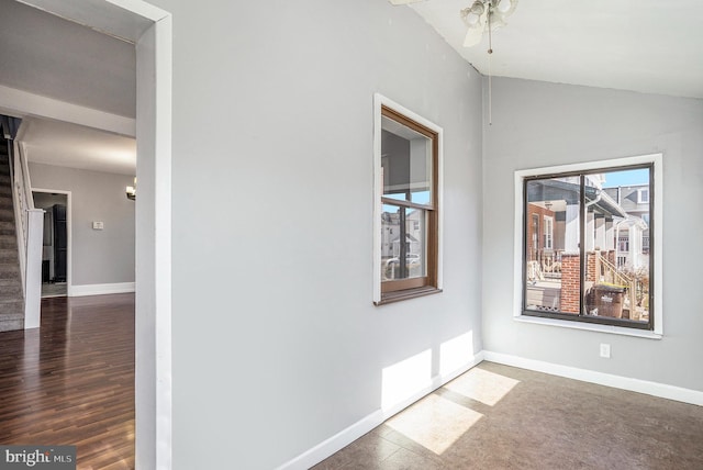 interior space with stairs, vaulted ceiling, wood finished floors, and baseboards