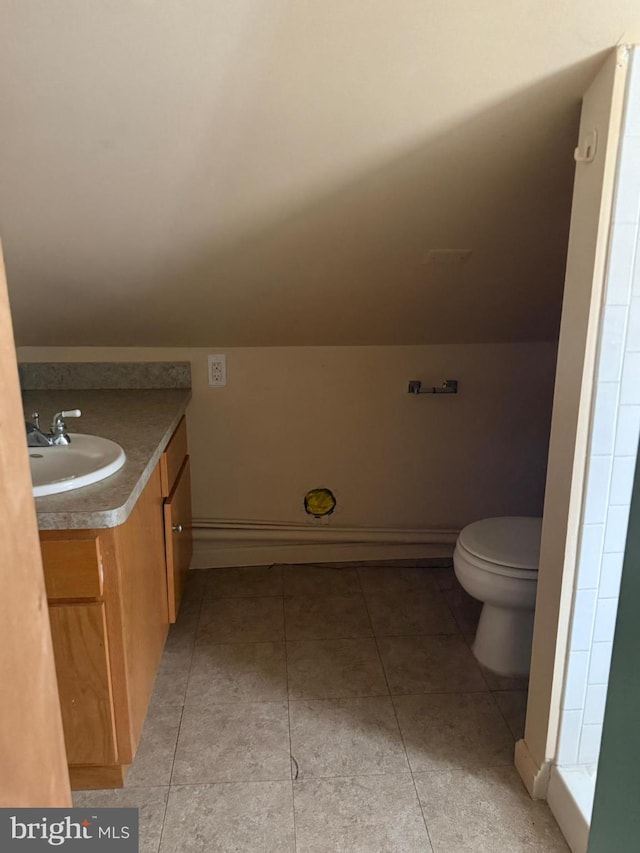 bathroom with vanity, tile patterned flooring, toilet, and lofted ceiling