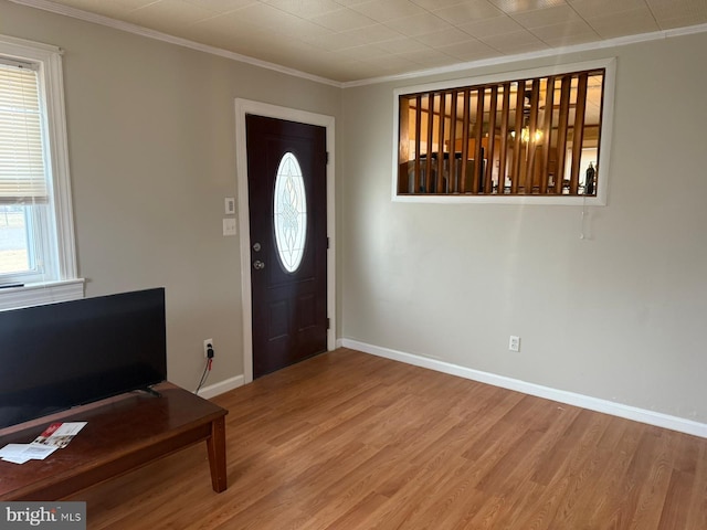 entrance foyer with hardwood / wood-style flooring, ornamental molding, and a wealth of natural light