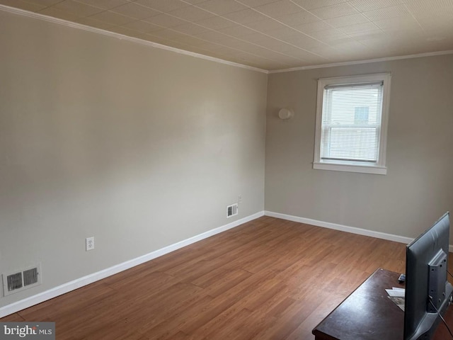 unfurnished room featuring hardwood / wood-style floors and ornamental molding