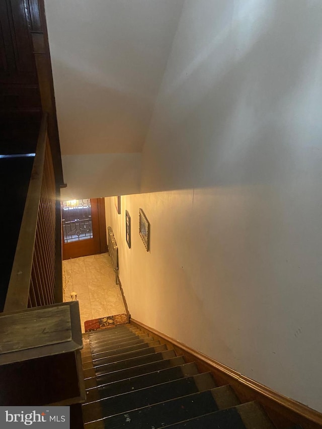 staircase featuring lofted ceiling