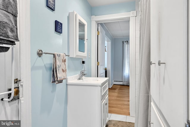 bathroom with a baseboard radiator, tile patterned flooring, and vanity