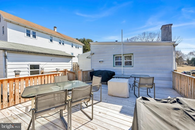 wooden deck with grilling area and outdoor dining space