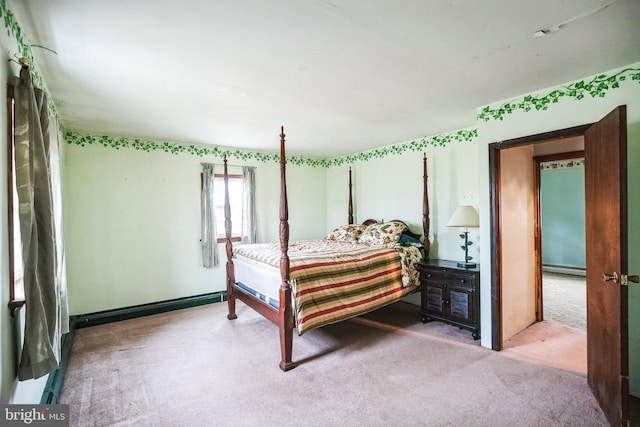 bedroom with a baseboard heating unit and light colored carpet