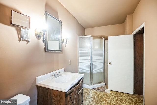 bathroom with a shower stall, vanity, and toilet