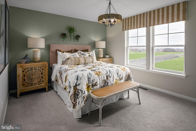 carpeted bedroom featuring a notable chandelier