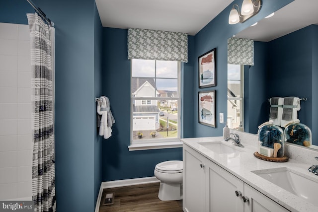 bathroom with toilet, hardwood / wood-style flooring, and vanity