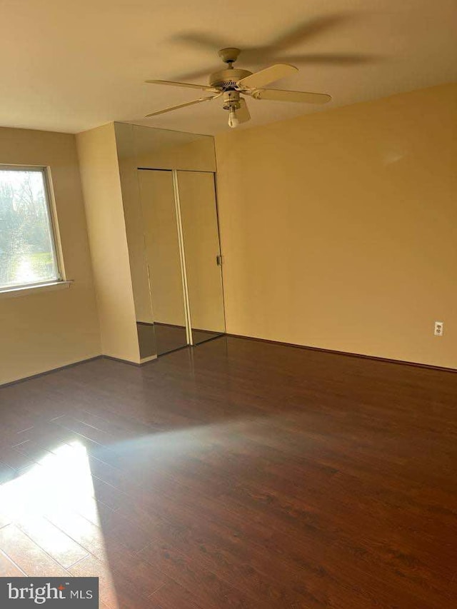 unfurnished room with ceiling fan and dark hardwood / wood-style flooring