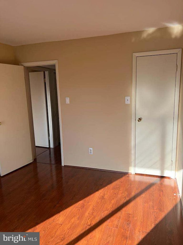 empty room with dark hardwood / wood-style flooring