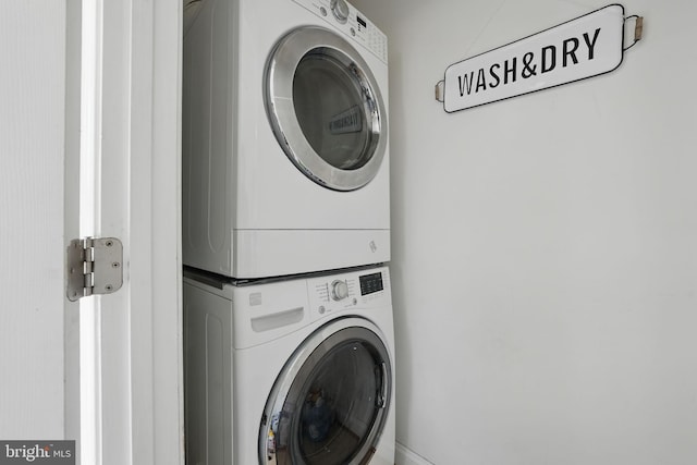 laundry room featuring stacked washer / dryer and laundry area
