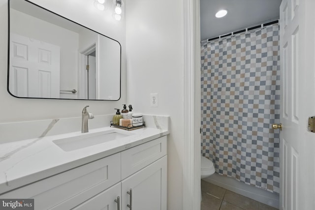bathroom with toilet, tile patterned floors, vanity, and curtained shower